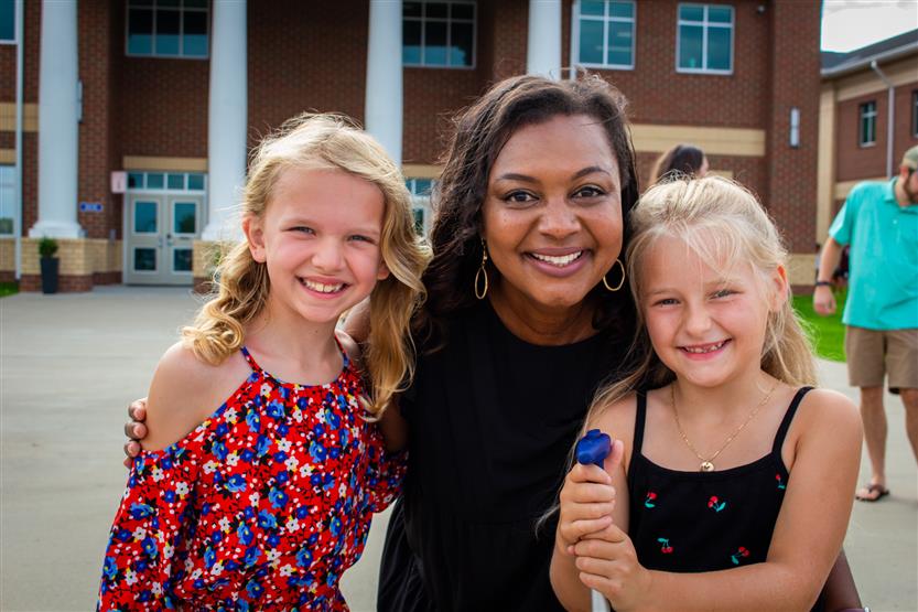 Two students smile with the Thompson's Station Elementary principal